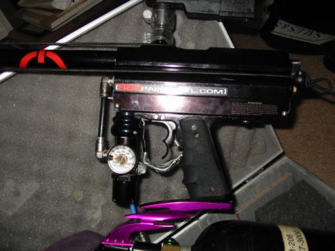 1986 Ford Bronco - A close-up view of a black paintball marker with visible text and a pressure gauge.