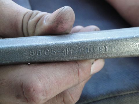 1995 Ford Taurus - A close-up view shows a metal automotive component with stamped identification numbers and text.
