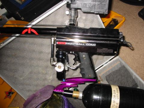 1986 Ford Bronco - A black paintball gun with a red design is shown next to a black air tank, with a purple mask in the foreground.