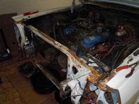 2001 Ford Crown Victoria - The engine bay of a car is shown with the hood open and some parts removed for repair.