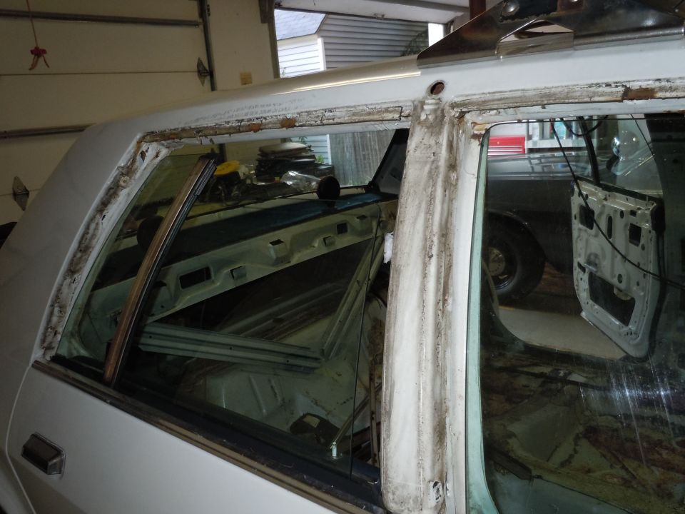 Interior of a car with doors removed, showing stripped-down panels and exposed metal