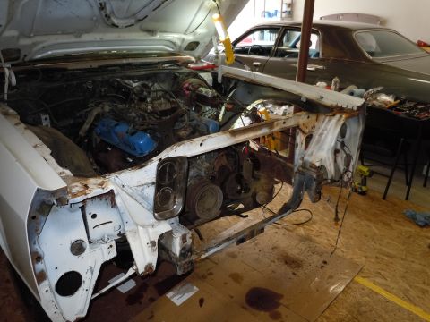 2001 Ford Crown Victoria - The engine bay of a white car is exposed, with a second dark sedan visible in the background of the garage.