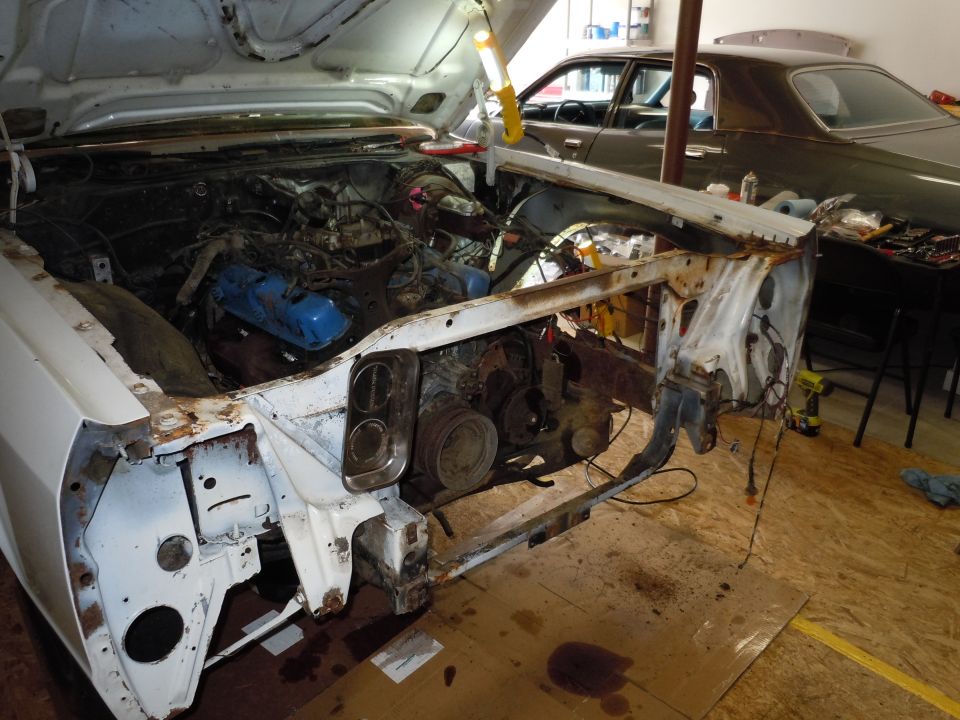 White car engine bay with hood open, dark car in background
