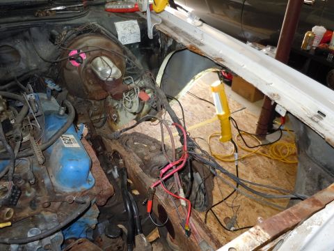 2001 Ford Crown Victoria - The engine bay is exposed, showing the brake booster, wiring, and engine components, with a work light illuminating the area.