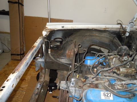 2001 Ford Crown Victoria - The engine bay of a car shows blue valve covers and significant rust on the chassis components.