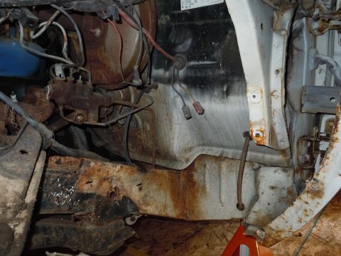 2001 Ford Crown Victoria - Close-up view of corroded engine bay components and frame structure.