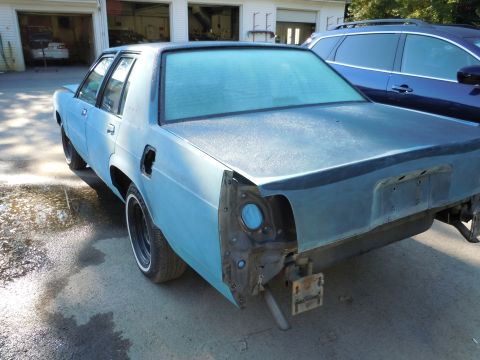 2001 Ford Crown Victoria - This sedan is missing its rear bumper and taillights, and appears to be in the process of being repainted.