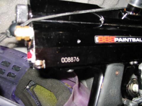 1986 Ford Bronco - Close-up of a black paintball gun, showing its serial number and brand name.
