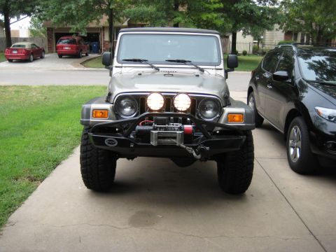 2005 Jeep Wrangler - This 2005 Jeep Wrangler features an aftermarket bumper, winch, and PIAA lights, presented in a front-facing view.