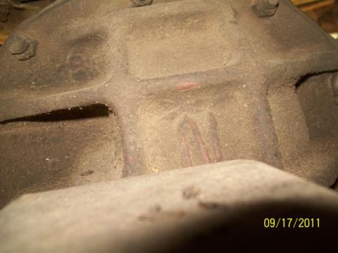 1979 Ford F-150 - A close-up view of a heavily soiled differential housing, showing some red paint marks and a date.