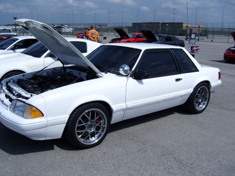 2007 Ford Mustang - A white 1987 Ford Mustang coupe is displayed with its hood open at a car show.