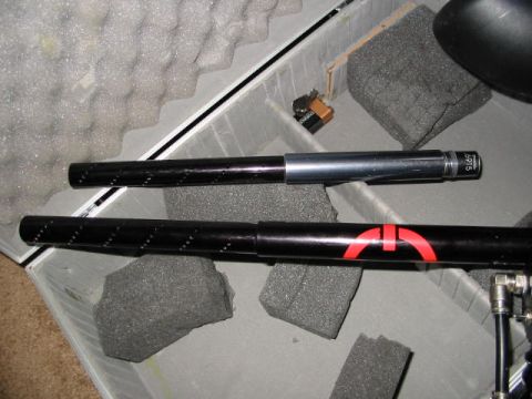 1986 Ford Bronco - Two black paintball gun barrels are visible inside a case, one with red markings and the other with a silver section.