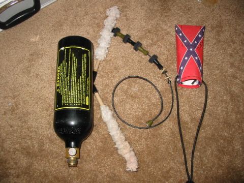 1986 Ford Bronco - A black CO2 tank with a yellow warning label and cleaning brushes are displayed next to a sleeve decorated with the Confederate flag.