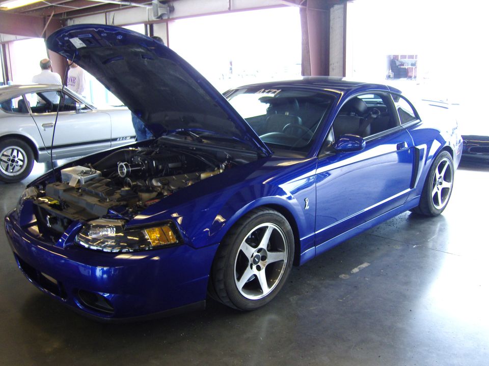 Blue 2007 Ford Mustang coupe with hood open, showing engine. Front 3/4 view