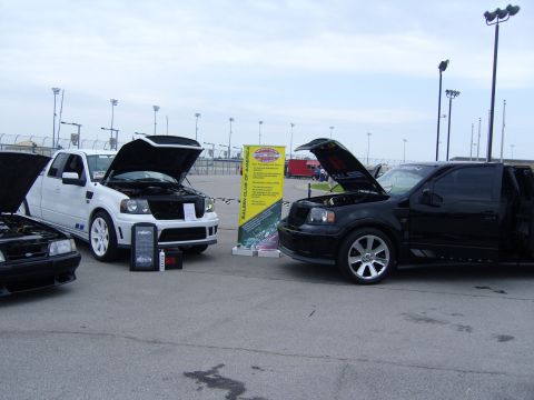 2007 Ford Mustang - Three vehicles displayed at a car show, including two Ford F-150 trucks and a Ford Mustang.