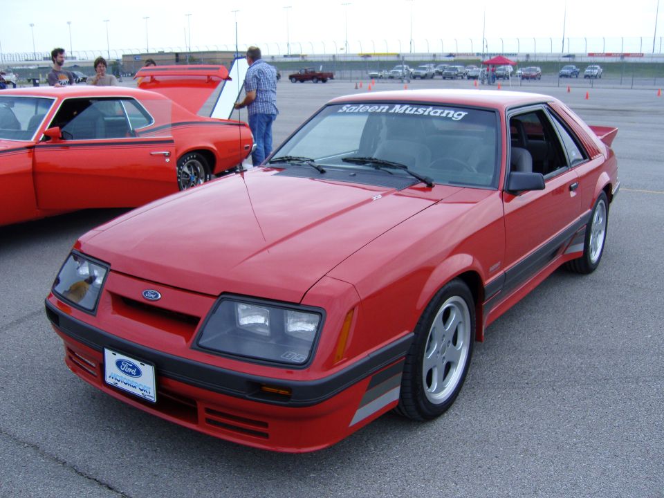 Red Saleen Mustang with a black stripe and silver accents, parked on asphalt