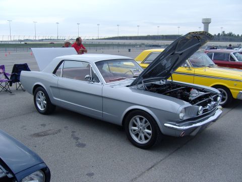 2007 Ford Mustang - Silver 1965 Ford Mustang coupe at a car show, hood open, with other vehicles nearby.