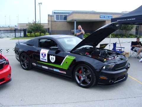 2007 Ford Mustang - A black 2007 Ford Mustang is displayed with its hood open, adorned with racing decals and green accents.