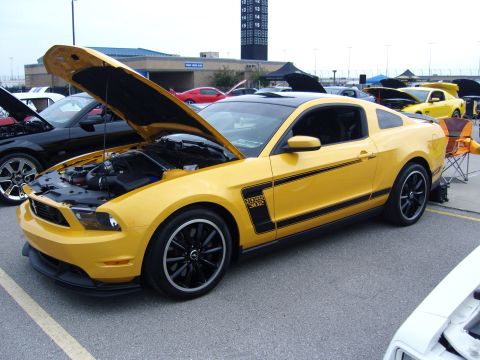 2007 Ford Mustang - A yellow Ford Mustang Boss 302 is displayed with its hood open at a car show.