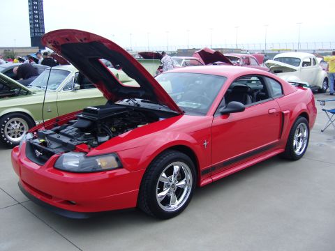 2007 Ford Mustang - Red Mustang on display at a car show with its hood up.