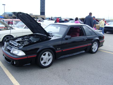 2007 Ford Mustang - A black 1987-1993 Ford Mustang GT 5.0 is displayed with its hood open, revealing the engine bay and red interior.