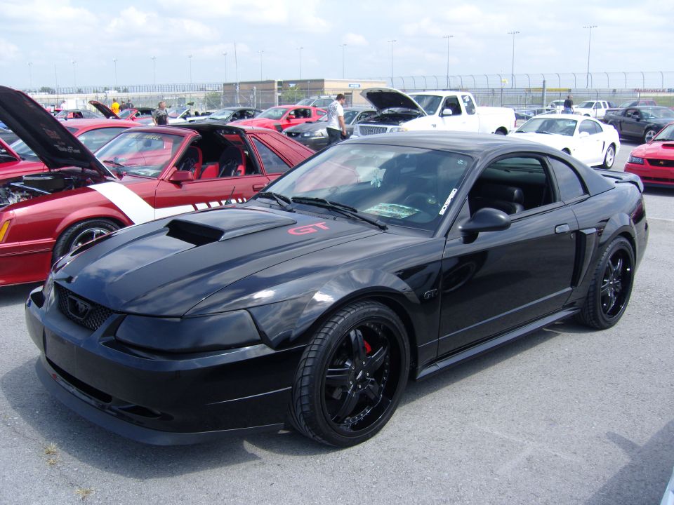 Black 2007 Ford Mustang GT parked at an outdoor car show with other vehicles visible