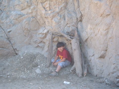 1988 Ford Bronco - A young boy sits in a natural alcove, which has been reinforced with wooden posts.
