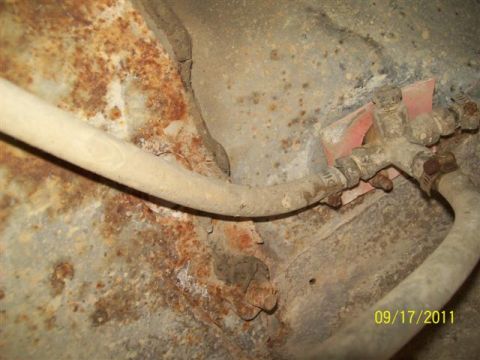 1979 Ford F-150 - Close-up of corroded vehicle undercarriage with fuel lines and hose clamps visible.