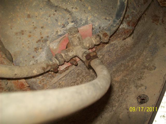 Fuel line valve with hoses attached, rusty undercarriage