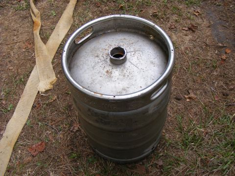 1978 Ford Bronco - A metal beer keg sits on the ground next to some burlap straps.