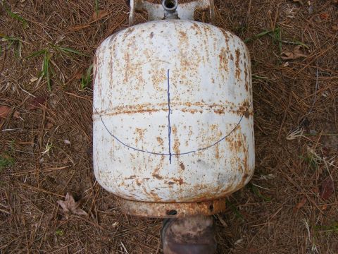 1978 Ford Bronco - Propane tank with blue lines drawn on it, sitting on the ground.