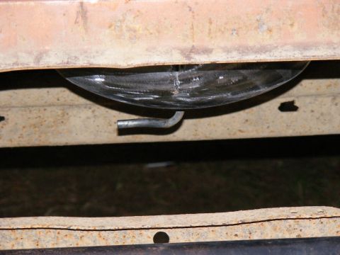 1978 Ford Bronco - The image shows a close-up view of a vehicle's fuel tank and its mounting strap from underneath.