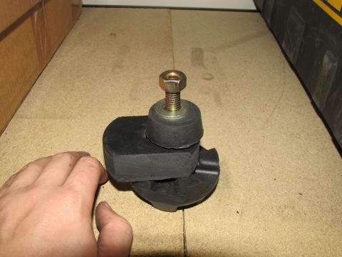 1993 Ford F-250 - A hand is shown near a rubber and metal mount with a bolt and nut on a workbench.