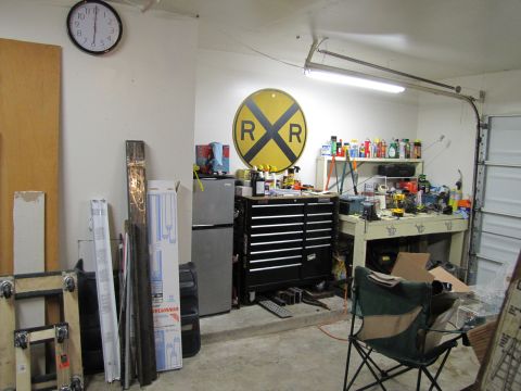 1993 Ford F-250 - A cluttered garage scene features a tool chest, workbench, refrigerator, and a prominent railroad crossing sign on the wall.