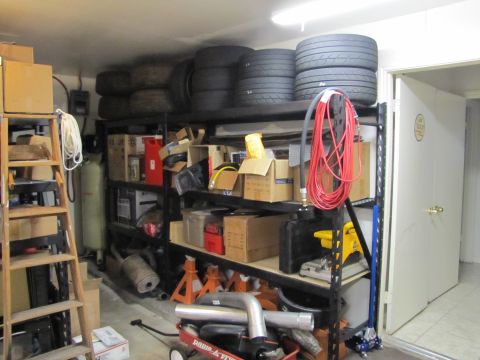 1993 Ford F-250 - A cluttered garage scene with various storage items, including tires, boxes, and equipment, filling the shelves.