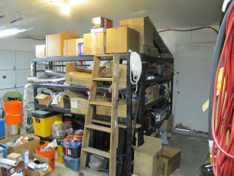 1993 Ford F-250 - A cluttered garage scene with storage shelves filled with various items and a ladder.