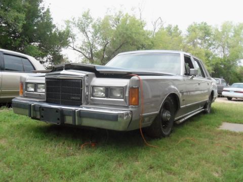 2000 Mercury Grand Marquis - This Lincoln Town Car appears to be from the 1980s, not a 2000 model, and is missing a wheel.