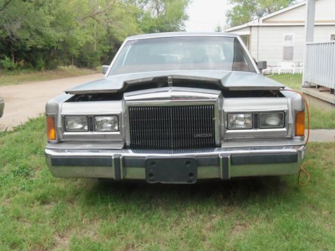 2000 Mercury Grand Marquis - This Lincoln Town Car, likely from the 1980s, is shown with its hood open, revealing the front grille with "LINCOLN" text.