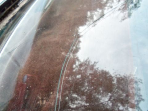 2000 Mercury Grand Marquis - A close-up view of a damaged windshield shows reflections of the surrounding environment and a website logo.