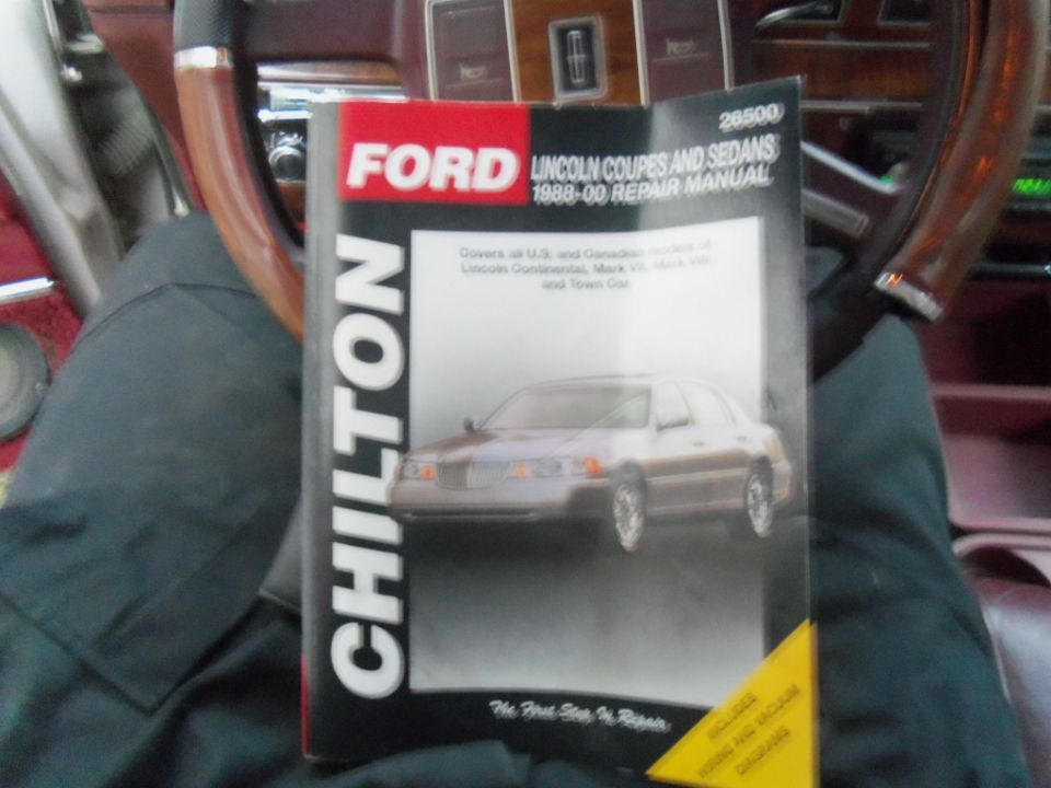 Photo of a Chilton Ford and Lincoln 1988-00 repair manual book cover held in a car
