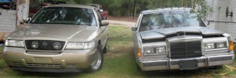 2000 Mercury Grand Marquis - Two sedans, a 2000 Mercury Grand Marquis and a Lincoln Town Car, are parked outdoors.