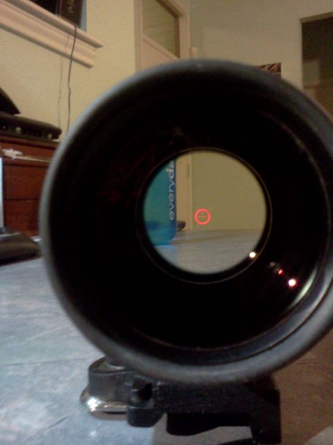 1996 Ford Bronco - The image shows a view through a scope, focusing on a red reticle against a backdrop of a room.