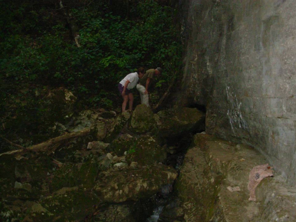 The water flows out through a lower buried entrance into a vertical shaft that rains down into a bowl, and then out this short tunnel.  Some people crawl in & sit under the shower.