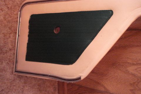 1979 Ford Bronco - Interior door panel trim piece with a textured insert and a central screw hole.