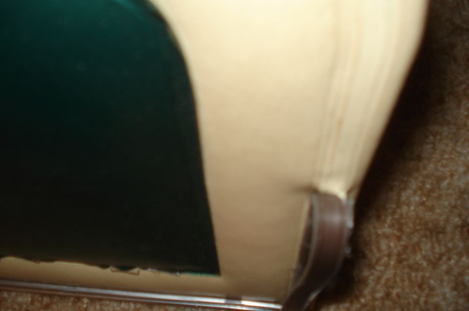 Tan interior upholstery meets a dark green panel, with a brown strap visible