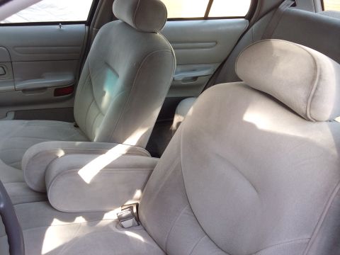 1998 Ford Crown Victoria - The interior of a car shows the front seats and door panels with light gray upholstery.