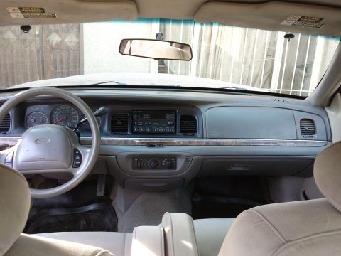 1998 Ford Crown Victoria - The interior of a car, showing the dashboard, steering wheel, and front seats.