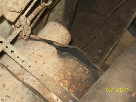 1979 Ford F-150 - Close-up view of the undercarriage of a vehicle, focusing on a damaged exhaust system.