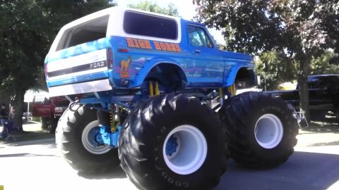1989 Ford Bronco - A modified Ford Bronco, painted blue with 'High Horse' graphics, sits on massive tires.