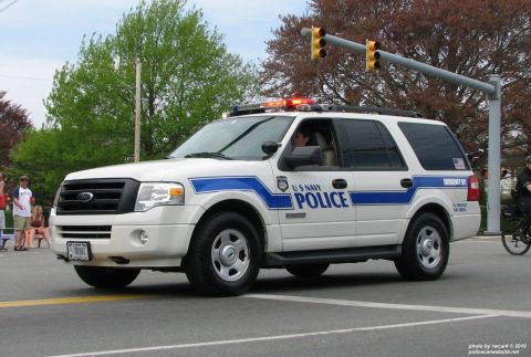 2006 Ford F-150 - A Ford Expedition marked as US Navy Police drives down a street with traffic lights overhead.